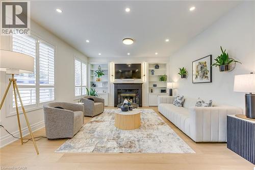 The living area features hardwood floors, recessed lighting, and a fireplace with a dark mantel - 4267 Sarazen Drive, Burlington, ON - Indoor Photo Showing Living Room With Fireplace