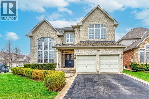 This property features a brick exterior, an integrated two-car garage, and a paved driveway - 4267 Sarazen Drive, Burlington, ON - Outdoor With Facade