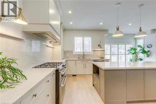 The kitchen features a range with a griddle, a built-in hood, and light-colored countertops - 4267 Sarazen Drive, Burlington, ON - Indoor Photo Showing Kitchen With Upgraded Kitchen