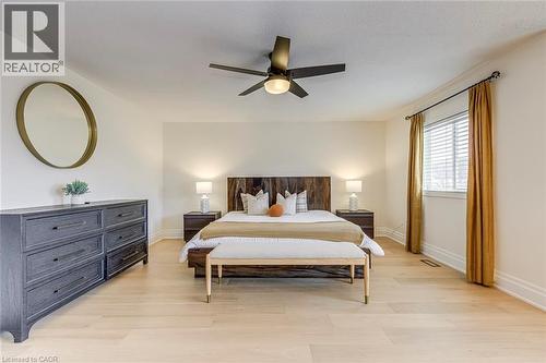 This room features light hardwood flooring, a ceiling fan with integrated lighting, and a window with blinds - 4267 Sarazen Drive, Burlington, ON - Indoor Photo Showing Bedroom