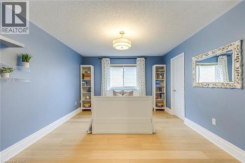 This room features hardwood flooring, blue walls, and a white ceiling - 4267 Sarazen Drive, Burlington, ON - Indoor