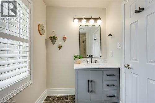 Bathroom featuring a grey vanity with dark hardware, a white countertop, and a contemporary mirror with a four-light fixture - 4267 Sarazen Drive, Burlington, ON - Indoor Photo Showing Bathroom