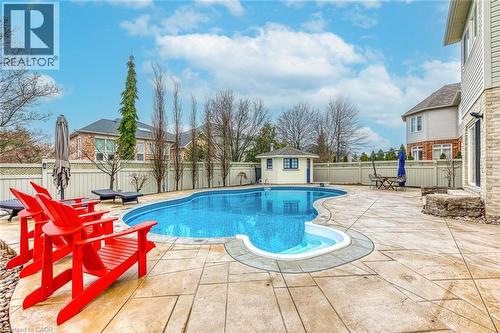 The property features an outdoor swimming pool, a pool house, and a spacious patio area - 4267 Sarazen Drive, Burlington, ON - Outdoor With In Ground Pool With Deck Patio Veranda