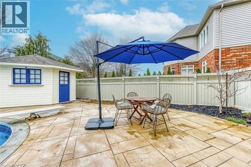 The outdoor patio features a light-colored paved surface, a white privacy fence, and a brick exterior on the main residence - 4267 Sarazen Drive, Burlington, ON - Outdoor With Deck Patio Veranda