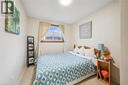 This room features warm neutral-toned walls, a window with a wood frame, and carpeting - 217 Johanna Drive, Cambridge, ON - Indoor Photo Showing Bedroom