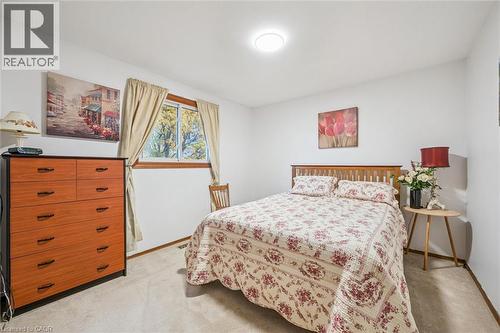 This bedroom features a window with natural wood trim, providing natural light, and a ceiling light fixture - 217 Johanna Drive, Cambridge, ON - Indoor Photo Showing Bedroom