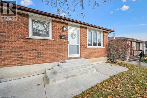 The property features a brick exterior with white trim windows and a white storm door - 217 Johanna Drive, Cambridge, ON - Outdoor