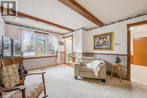 Living area featuring carpeted flooring, a large bay window, and exposed ceiling beams - 217 Johanna Drive, Cambridge, ON - Indoor