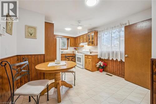 The kitchen features wooden cabinetry, white appliances, and a window with white curtains - 217 Johanna Drive, Cambridge, ON - Indoor Photo Showing Other Room
