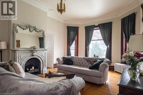 the Original fireplace mantel is exquisite! - 347 Queen Street S, Hamilton, ON - Indoor Photo Showing Living Room With Fireplace
