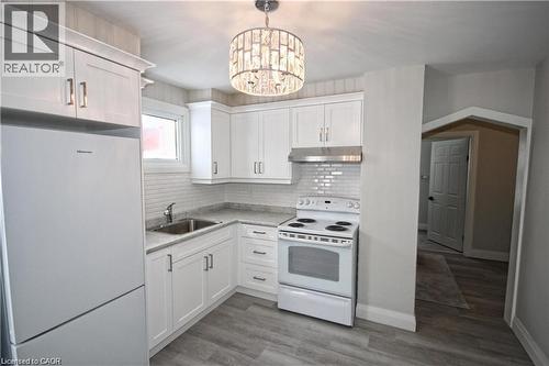 Kitchen featuring white cabinetry, a white stove, a white refrigerator, and a stainless steel sink - 1356 Upper Wellington Street, Hamilton, ON - Indoor Photo Showing Kitchen