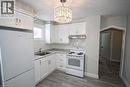 Kitchen featuring white cabinetry, a white stove, a white refrigerator, and a stainless steel sink - 1356 Upper Wellington Street, Hamilton, ON  - Indoor Photo Showing Kitchen 