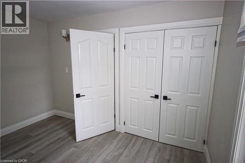 This room features light gray wood-style flooring, light-colored walls, and white trim - 1356 Upper Wellington Street, Hamilton, ON - Indoor Photo Showing Other Room
