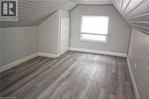 This room features light grey wood-look flooring, a window with a roller blind, and white baseboards - 1356 Upper Wellington Street, Hamilton, ON - Indoor Photo Showing Other Room