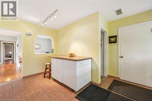 The property features a kitchen area with tile flooring, a built-in cabinet with a countertop, and a serving pass-through window - 155 Hungerford Road, Cambridge, ON - Indoor Photo Showing Other Room
