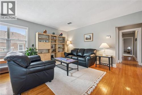 The living area features hardwood floors, a neutral wall color, and a window with blinds providing natural light - 155 Hungerford Road, Cambridge, ON - Indoor Photo Showing Living Room