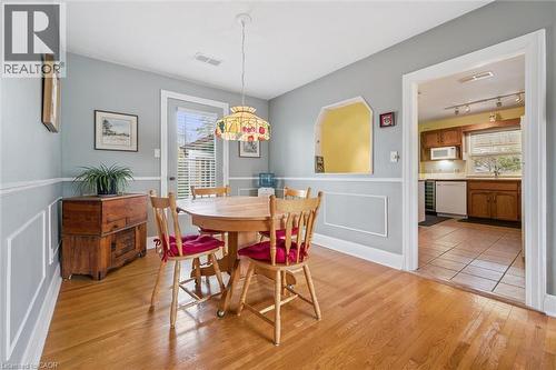 Dining area featuring hardwood floors, wainscoting, and a decorative pendant light fixture - 155 Hungerford Road, Cambridge, ON - Indoor Photo Showing Dining Room