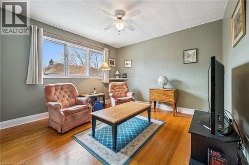 Living area featuring hardwood floors, light green walls, a large window, and a ceiling fan - 155 Hungerford Road, Cambridge, ON - Indoor