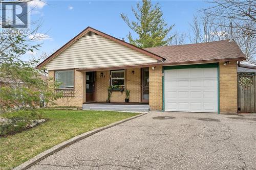The property features a brick exterior with a front-facing garage, a paved driveway, and a well-maintained lawn - 155 Hungerford Road, Cambridge, ON - Outdoor