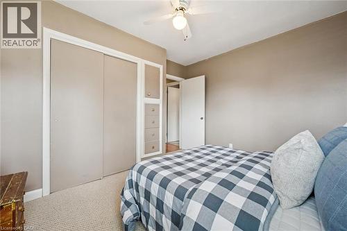 This room features a ceiling fan, carpeted flooring, and a closet with sliding doors and built-in drawers - 155 Hungerford Road, Cambridge, ON - Indoor Photo Showing Bedroom