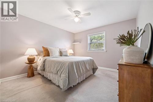 This room features light-colored walls and carpeting, a window with horizontal blinds, and a ceiling fan - 155 Hungerford Road, Cambridge, ON - Indoor Photo Showing Bedroom