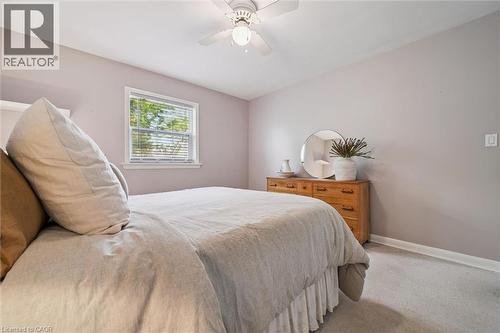 This room features light-colored walls and carpeting, a window with blinds, and a ceiling fan - 155 Hungerford Road, Cambridge, ON - Indoor Photo Showing Bedroom