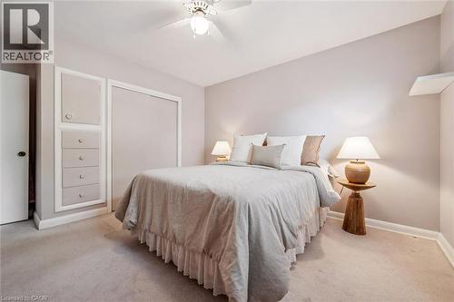 This room features light-colored walls and carpeting, a ceiling fan, a built-in storage unit with drawers, and a closet with sliding doors - 155 Hungerford Road, Cambridge, ON - Indoor Photo Showing Bedroom