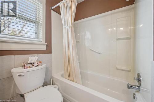Bathroom featuring a white toilet, tiled walls, and a bathtub with an integrated shower unit - 155 Hungerford Road, Cambridge, ON - Indoor Photo Showing Bathroom