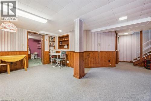 The property features a spacious room with carpeted flooring, wood paneling, and built-in shelving - 155 Hungerford Road, Cambridge, ON - Indoor