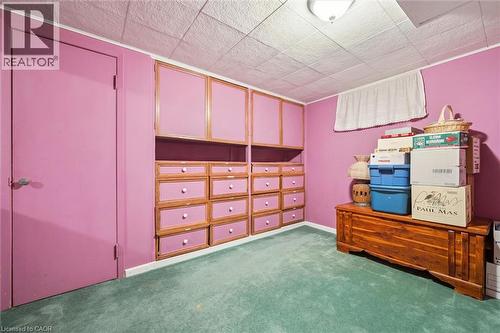 This room offers built-in cabinetry with drawers and cupboards, carpeted flooring, and a drop ceiling with an overhead light fixture - 155 Hungerford Road, Cambridge, ON - Indoor