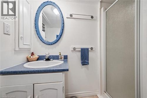 Bathroom featuring a vanity with a blue countertop, a white oval sink, and a framed oval mirror - 155 Hungerford Road, Cambridge, ON - Indoor Photo Showing Bathroom