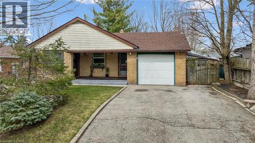 The property features a brick exterior with a pitched roof, an attached garage, and a paved driveway - 155 Hungerford Road, Cambridge, ON - Outdoor