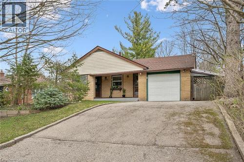 The property features an attached garage with a white door, a paved driveway, and brick and siding exterior - 155 Hungerford Road, Cambridge, ON - Outdoor