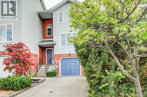 View of front facade with brick siding, an attached garage, and driveway - 633 Grange Crescent, Waterloo, ON - Outdoor
