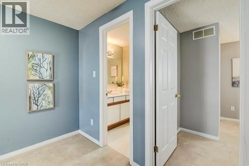 Corridor with light colored carpet and a textured ceiling - 633 Grange Crescent, Waterloo, ON - Indoor Photo Showing Other Room