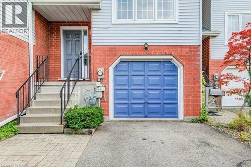 Entrance to property with a garage, brick siding, and driveway - 633 Grange Crescent, Waterloo, ON - Outdoor With Exterior