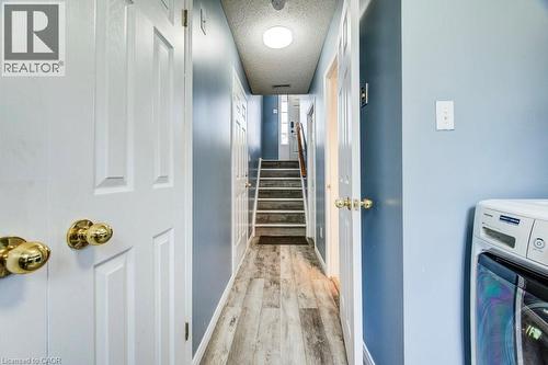 Hall with washer / clothes dryer, a textured ceiling, and light wood finished floors - 633 Grange Crescent, Waterloo, ON - Indoor