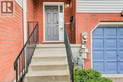 View of exterior entry featuring brick siding and an attached garage - 633 Grange Crescent, Waterloo, ON - Outdoor With Exterior