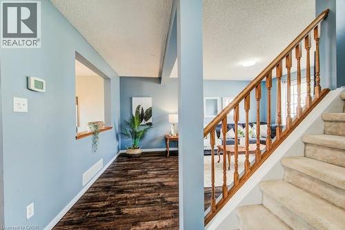 Stairs featuring wood finished floors and a textured ceiling - 633 Grange Crescent, Waterloo, ON - Indoor Photo Showing Other Room