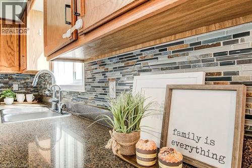 Kitchen view of backsplash and dark stone countertops - 633 Grange Crescent, Waterloo, ON - Indoor Photo Showing Kitchen With Double Sink