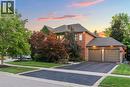 This property features a brick exterior with stone accents, a two-car garage with individual doors, and a paved driveway - 4278 Clubview Drive, Burlington, ON  - Outdoor 