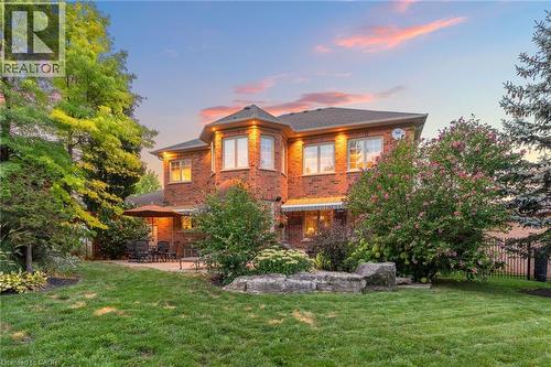 The property features a brick exterior with multiple windows and exterior lighting - 4278 Clubview Drive, Burlington, ON - Outdoor