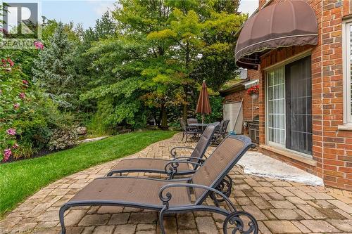 The property features a brick exterior with a sliding glass door leading to a paver patio - 4278 Clubview Drive, Burlington, ON - Outdoor With Deck Patio Veranda