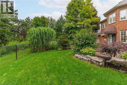 The property features a well-maintained lawn with mature trees and diverse landscaping, including large rock features - 4278 Clubview Drive, Burlington, ON - Outdoor