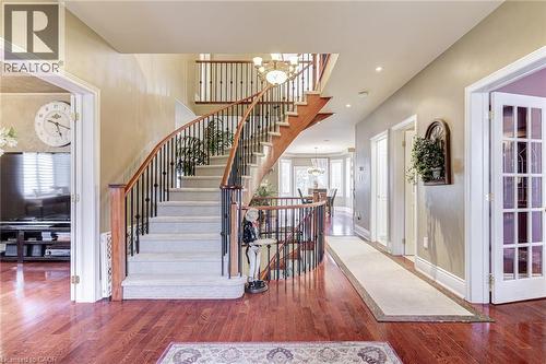 Grand entry foyer featuring hardwood floors, a curved staircase with wrought iron balusters, and crown molding - 4278 Clubview Drive, Burlington, ON - Indoor Photo Showing Other Room