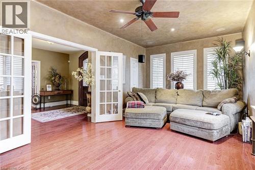 Living space featuring polished hardwood floors, a ceiling fan, and three windows with white louvered blinds - 4278 Clubview Drive, Burlington, ON - Indoor Photo Showing Living Room