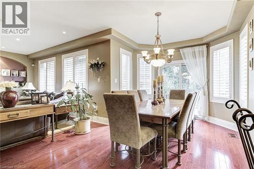 Dining area with hardwood floors, a bay window with plantation shutters, and a chandelier - 4278 Clubview Drive, Burlington, ON - Indoor Photo Showing Dining Room
