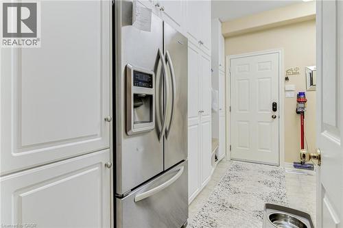 This space features white cabinetry and a stainless steel refrigerator with a water and ice dispenser - 4278 Clubview Drive, Burlington, ON - Indoor Photo Showing Other Room