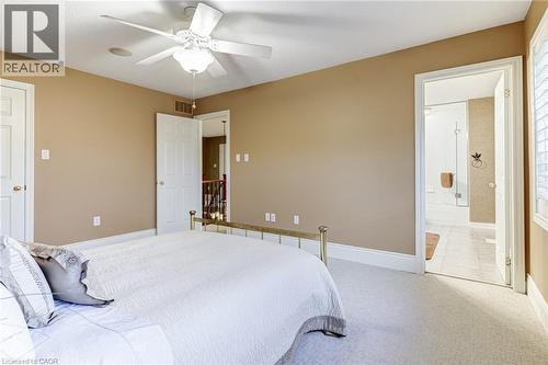 This room features soft neutral tone walls, a ceiling fan with integrated lighting, and plush carpeting - 4278 Clubview Drive, Burlington, ON - Indoor Photo Showing Bedroom