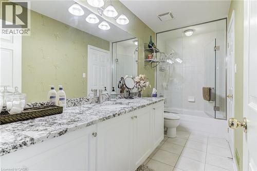 Bathroom featuring a double vanity with a speckled countertop, a large mirror, and a glass-enclosed shower - 4278 Clubview Drive, Burlington, ON - Indoor Photo Showing Bathroom